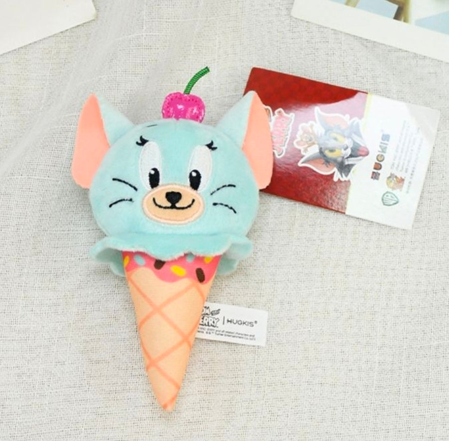 Light-blue plush ice cream cone keychain with cherry topper on fabric