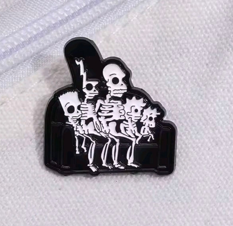 Enamel pin of a skeleton group under a dark arch frame, white and black