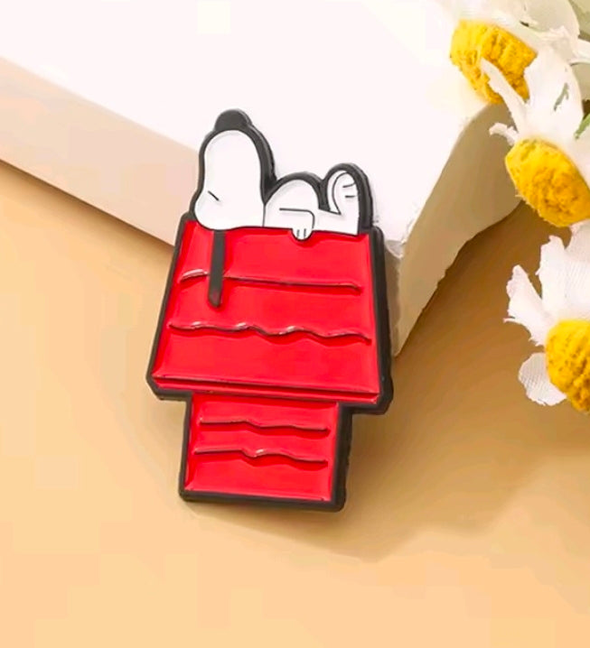 Red bag enamel pin with Snoopy head and white face, black outlines