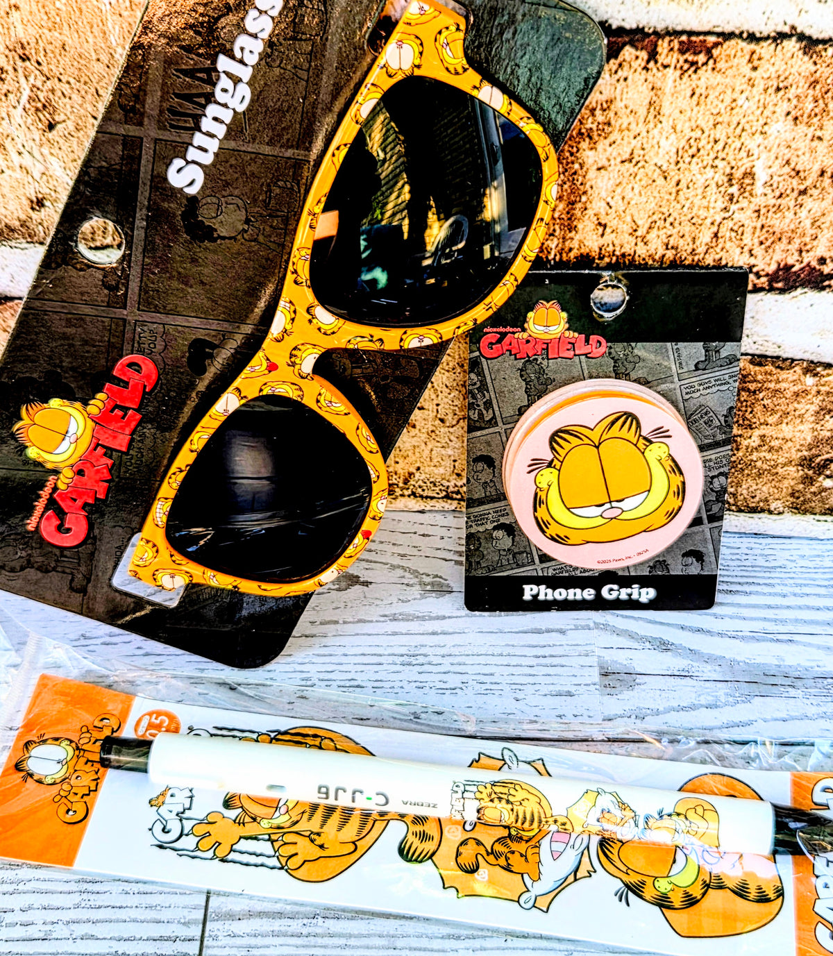 Garfield phone grip set with orange glasses frame, phone grip box, and character strip