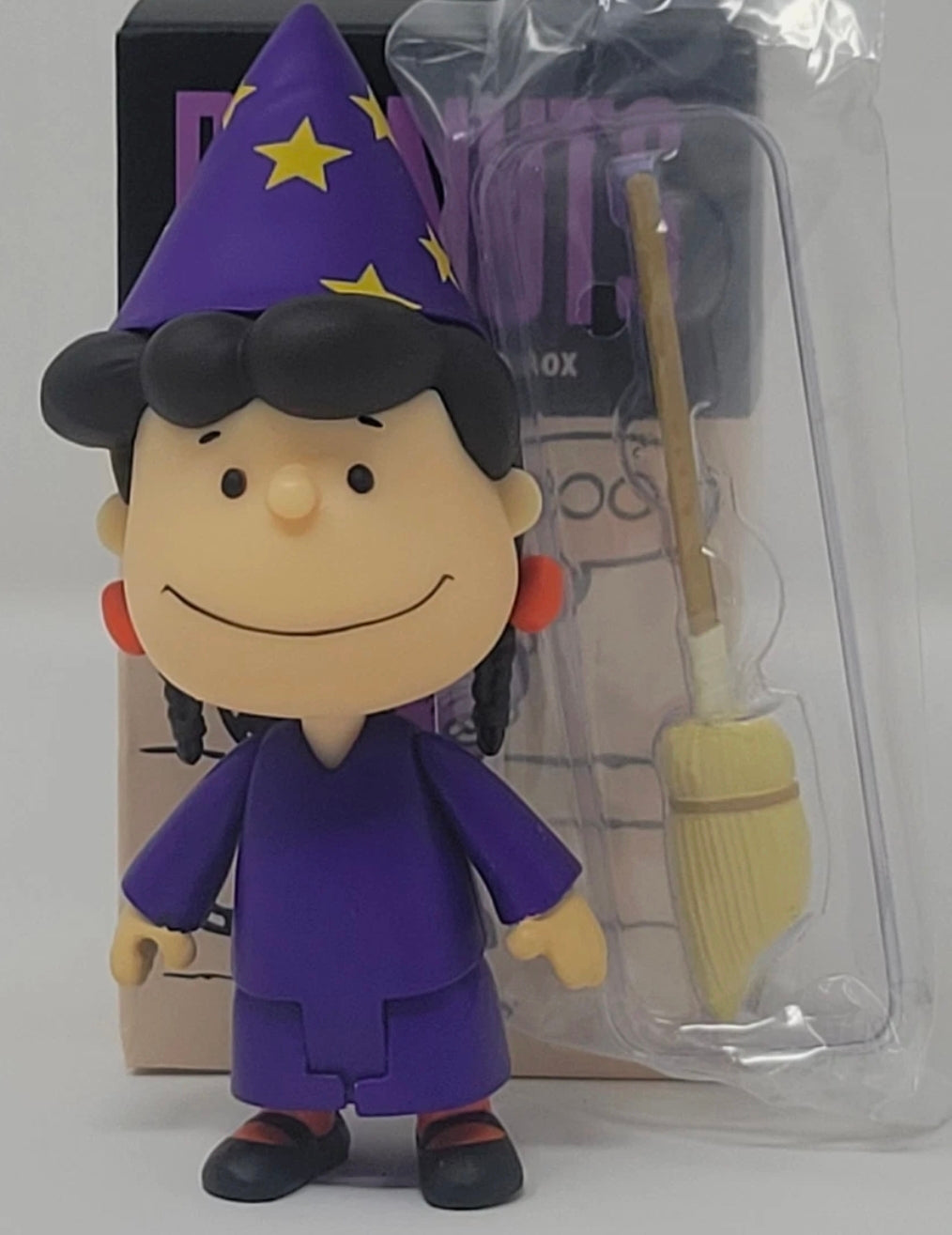 Halloween vinyl figure with purple outfit and pointed star wizard hat, shown in packaging