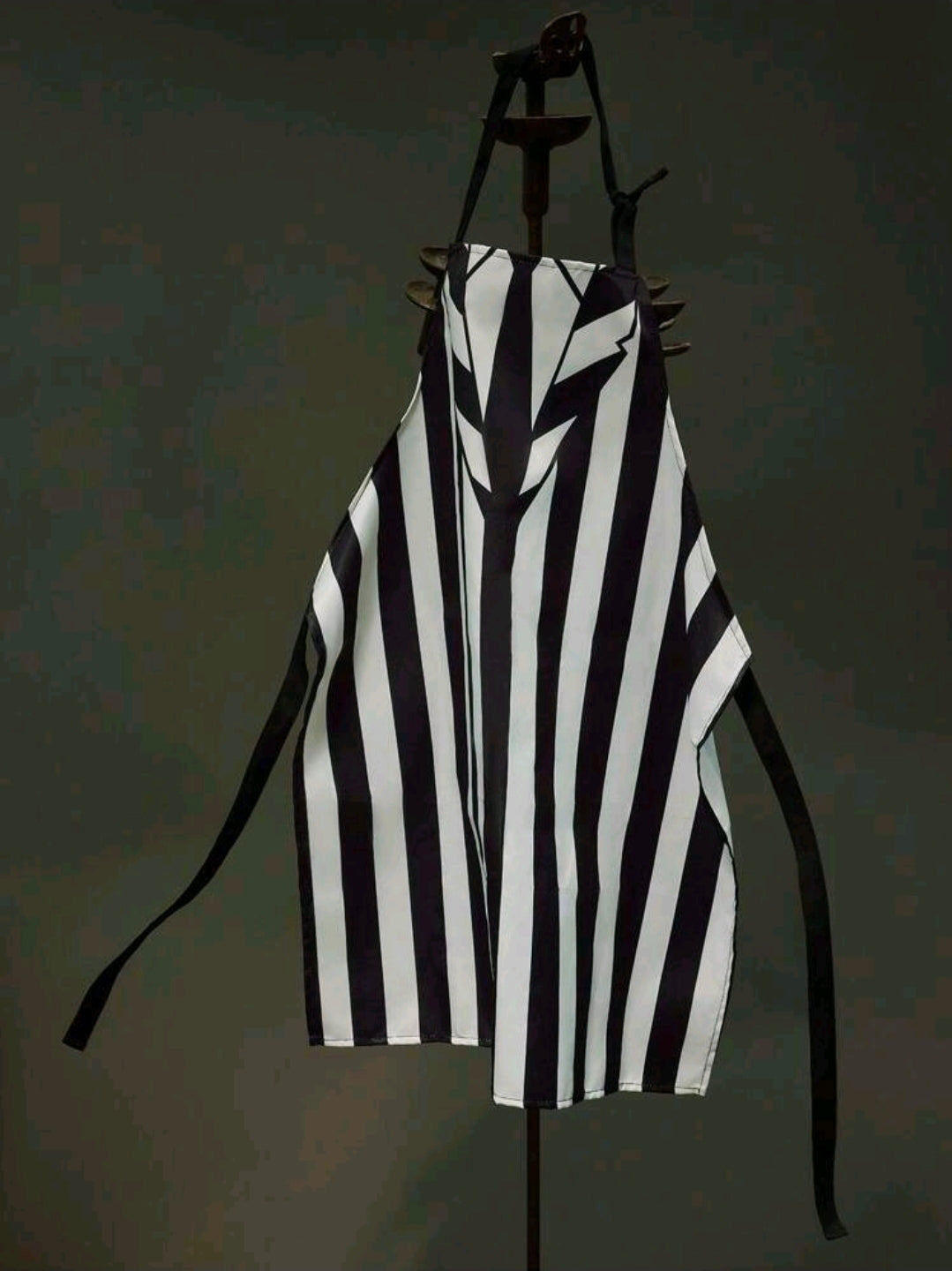 Black-and-white striped apron with tie straps and jagged chest print, one size