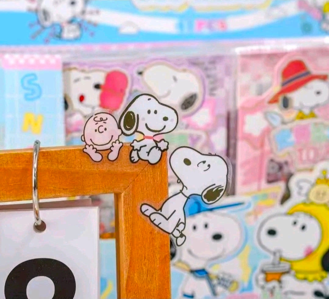 Snoopy character sticker stuck on a wooden surface with surrounding sheets