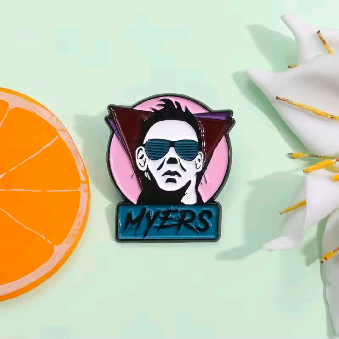 Enamel pin of Michael Myers face with blue sunglasses and pink spiked border