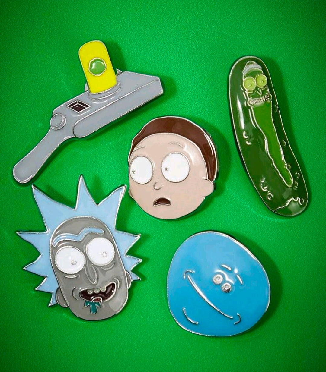 Five enamel character pins: portal gun, pickle Rick, Rick head, Meeseeks face, blue portal