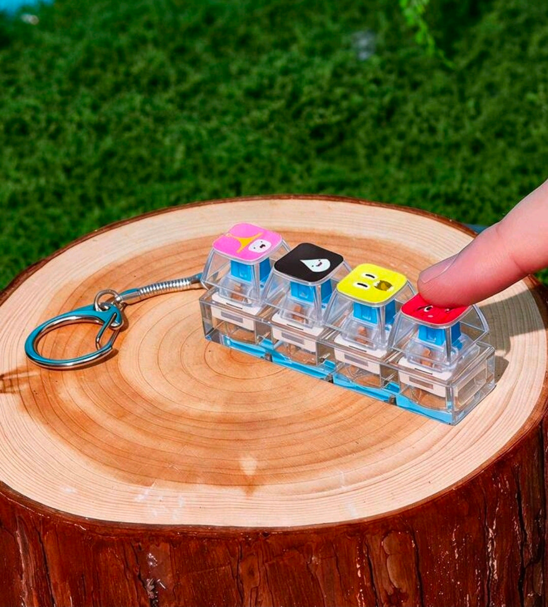 Hand holding clear stacked cube fidget keychain with character faces