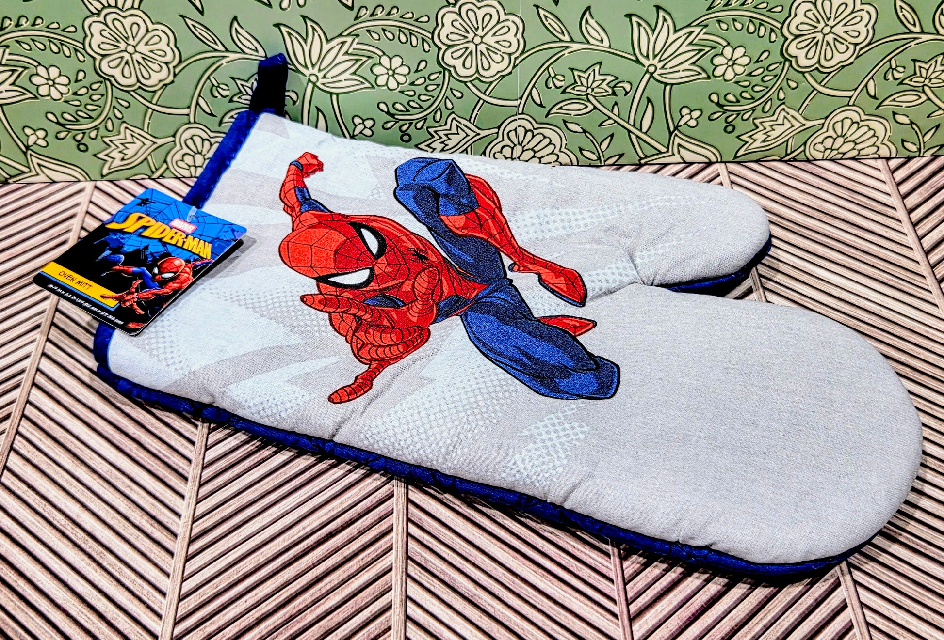Spider-Man oven mitt with red-and-blue character print on white fabric