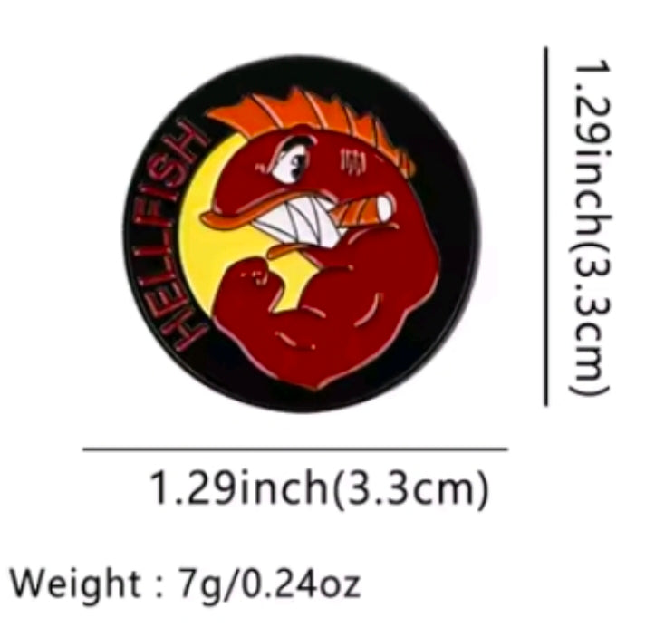 Round enamel pin with red cartoon character face in yellow and orange flames, black border