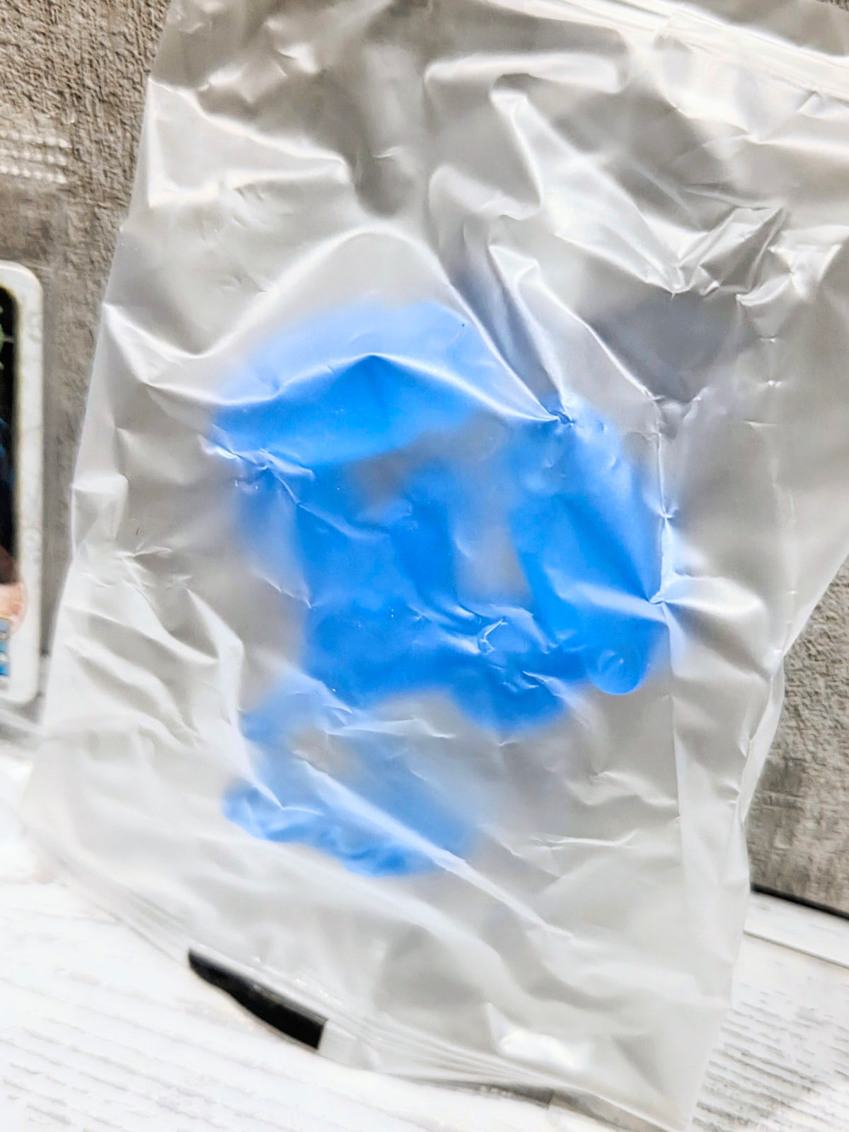 Sealed clear plastic bag with translucent blue figure silhouette inside