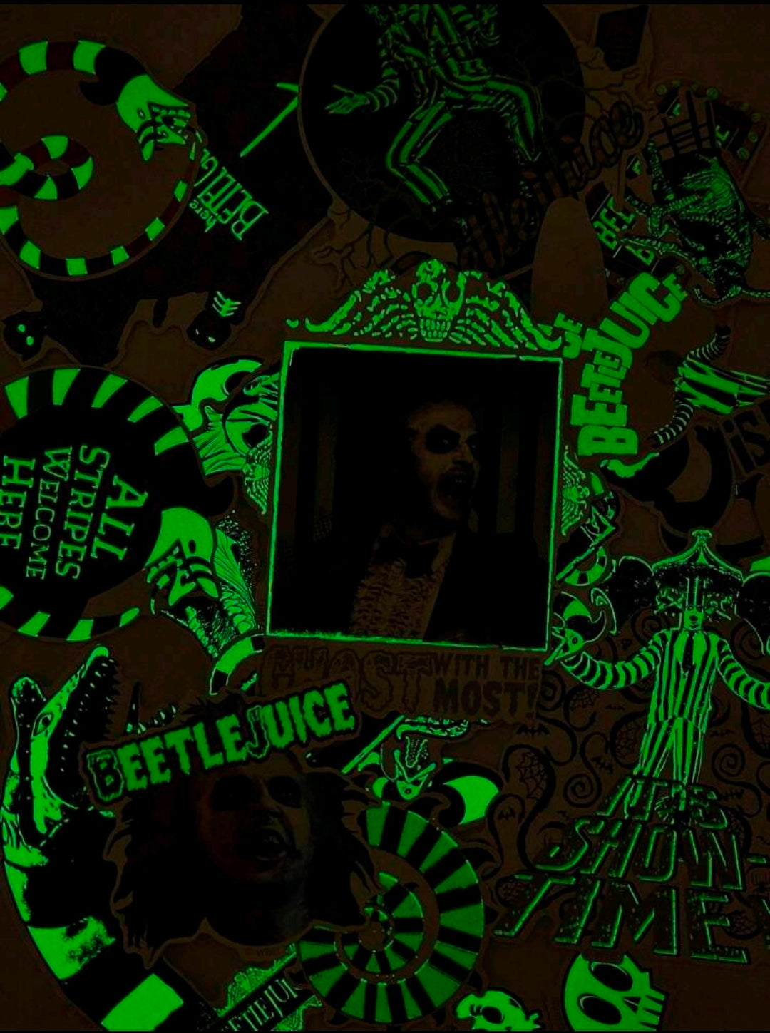 Glow-in-the-dark Beetlejuice stickers glowing green on dark background