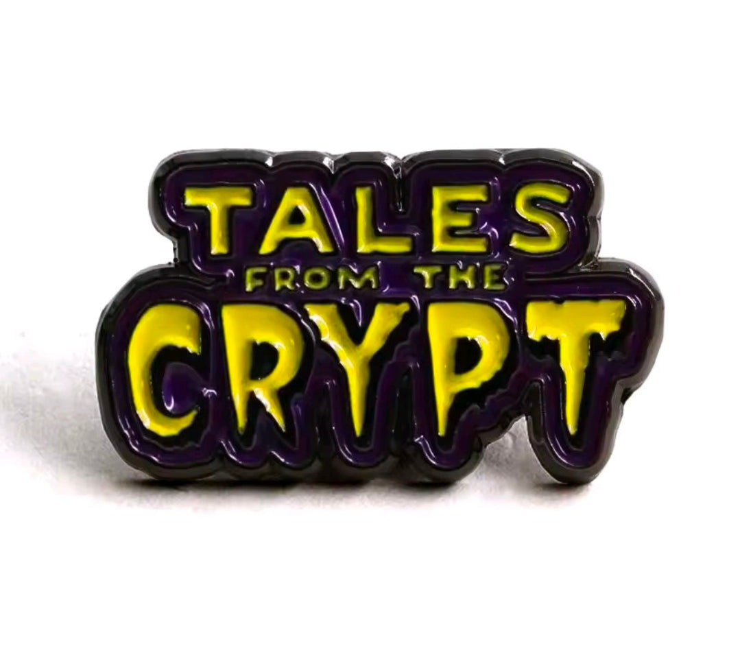 Tales from the Crypt enamel logo pin, raised black border with yellow and purple lettering.