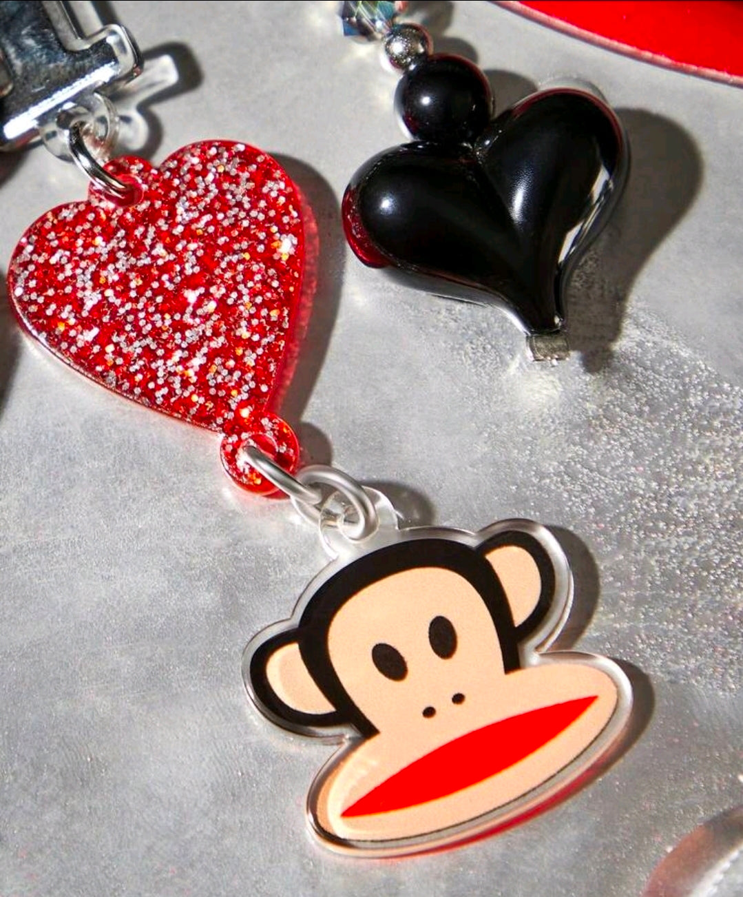 Keychain with red glitter heart, black heart, and monkey face tag charm