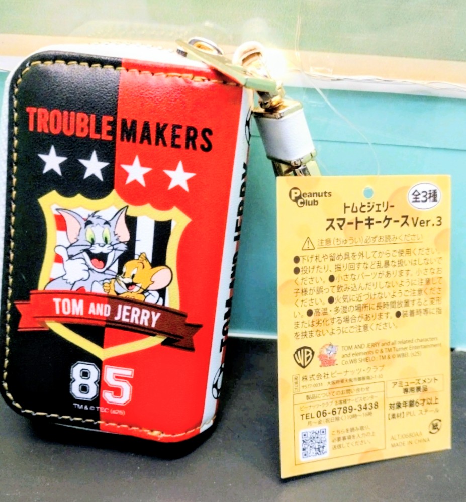Red-and-black smart key case “Trouble Makers” with hanging Tom and Jerry card