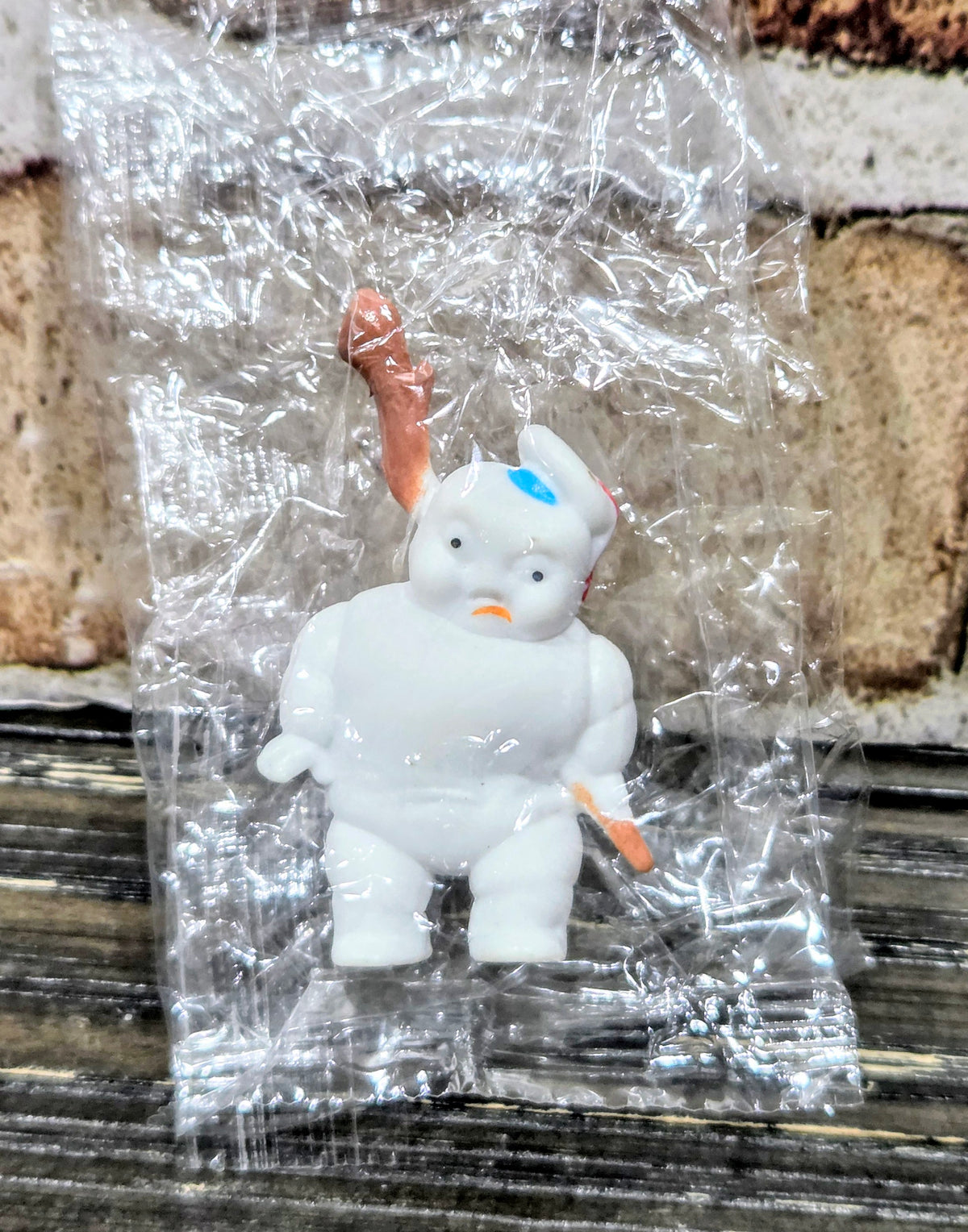 Toy mini figure with orange roasted-marshmallow stick and graham cracker base, sealed