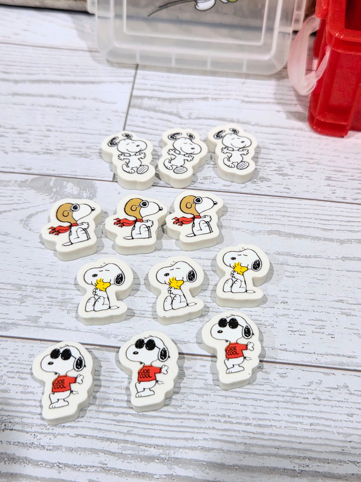 Set of Snoopy-shaped erasers with character faces and small colored details