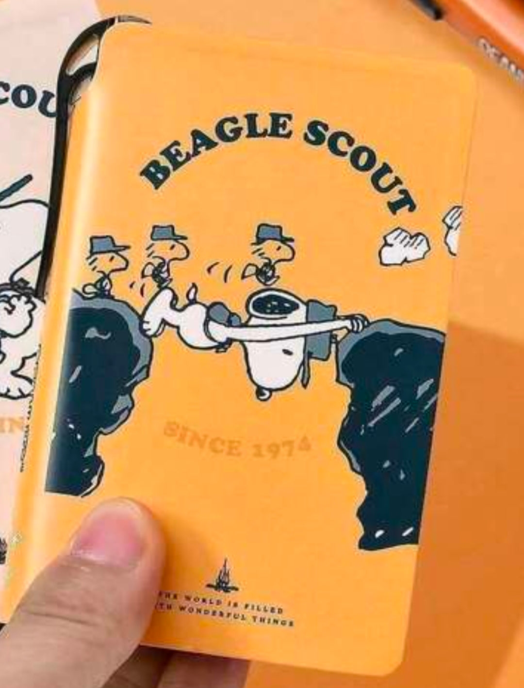 Orange Snoopy Beagle Scout faux leather pocket field notebook cover held in hand