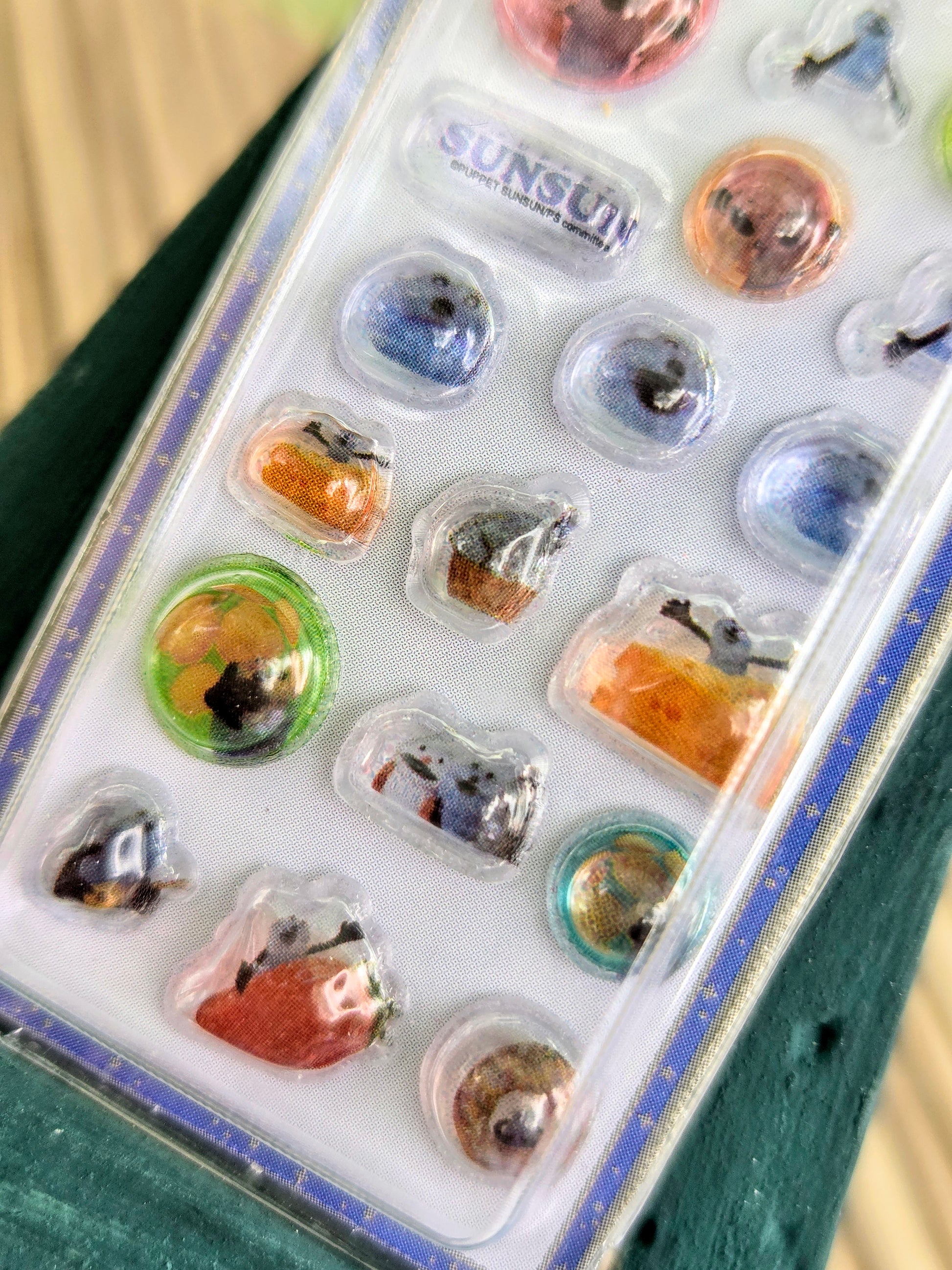Close-up of clear blister sticker keychain pack with mixed blue, orange, and green icons