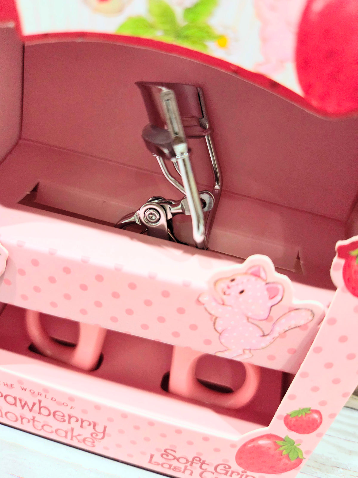 Pink strawberry eyelash curler tray with metal clamp and handle