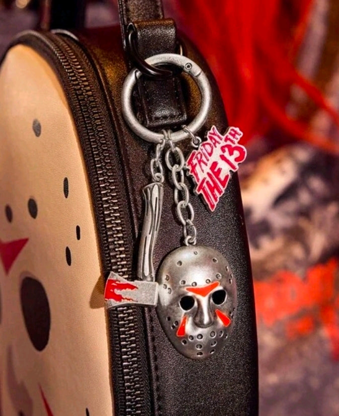 Metal hockey mask keychain with red-and-white logo charm on dark strap