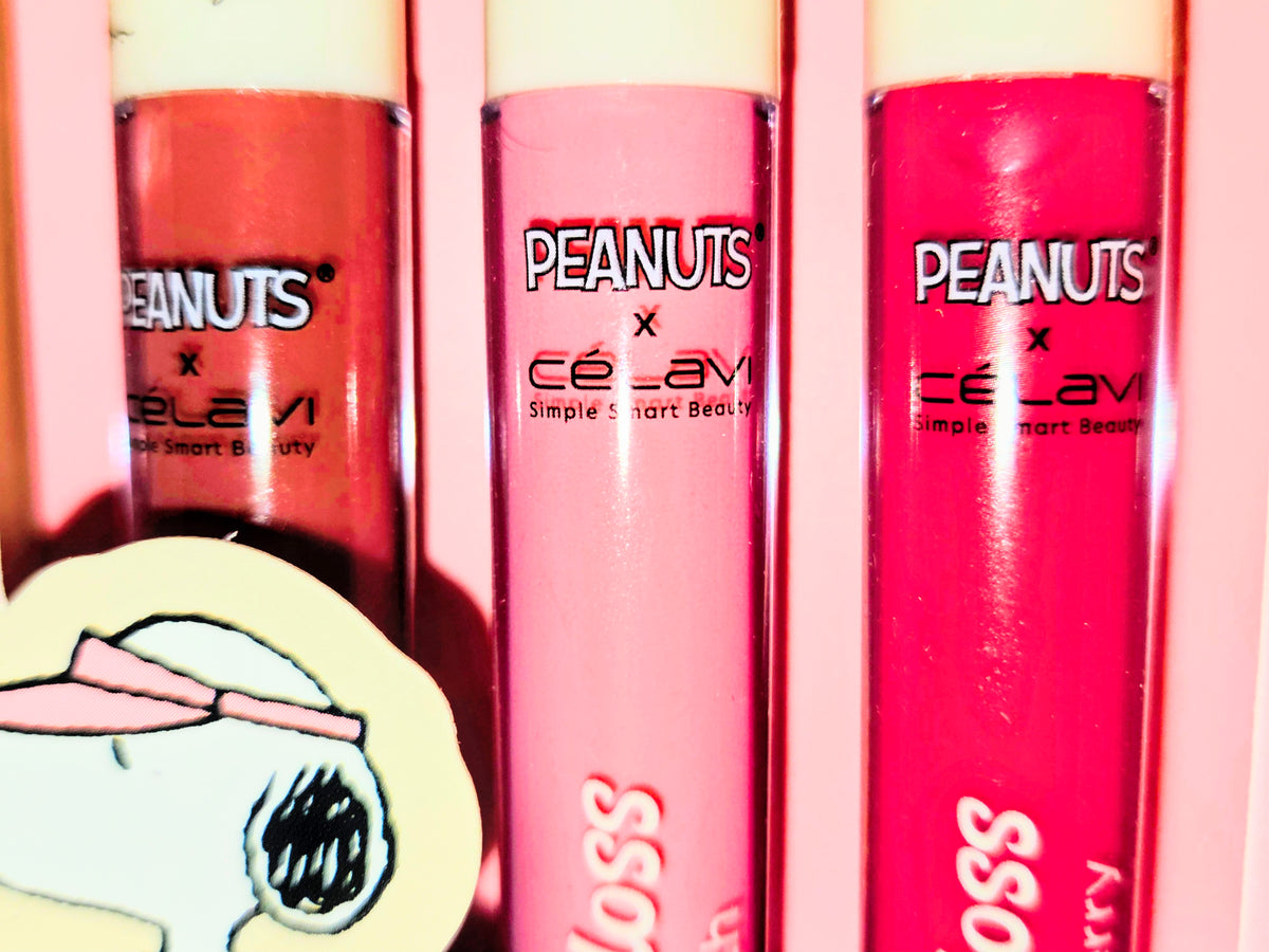 Close-up of PEANUTS x Celavi lip gloss tubes with Snoopy graphics and gloss caps