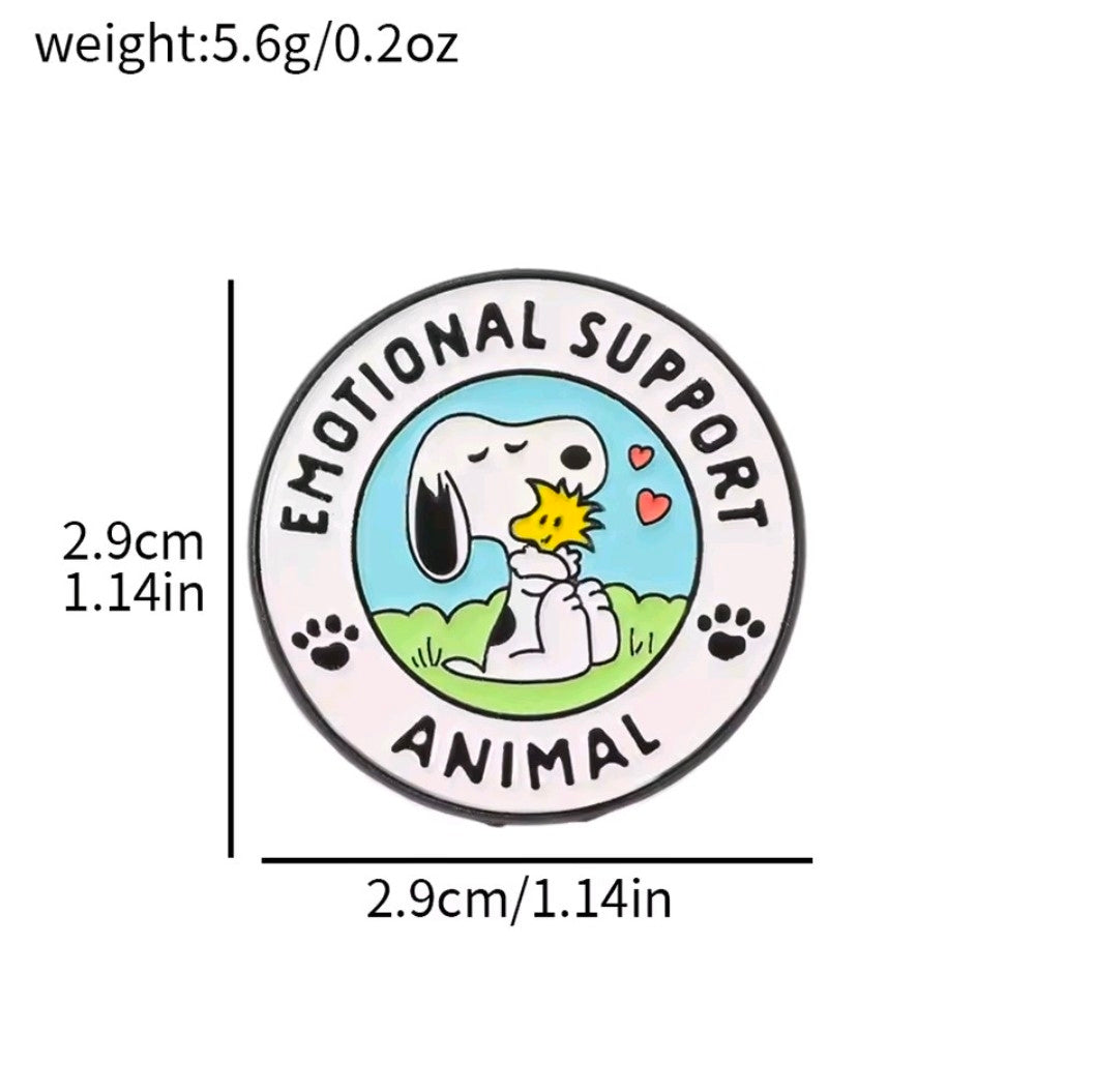 Round enamel pin with Snoopy holding a small yellow bird, blue sky background