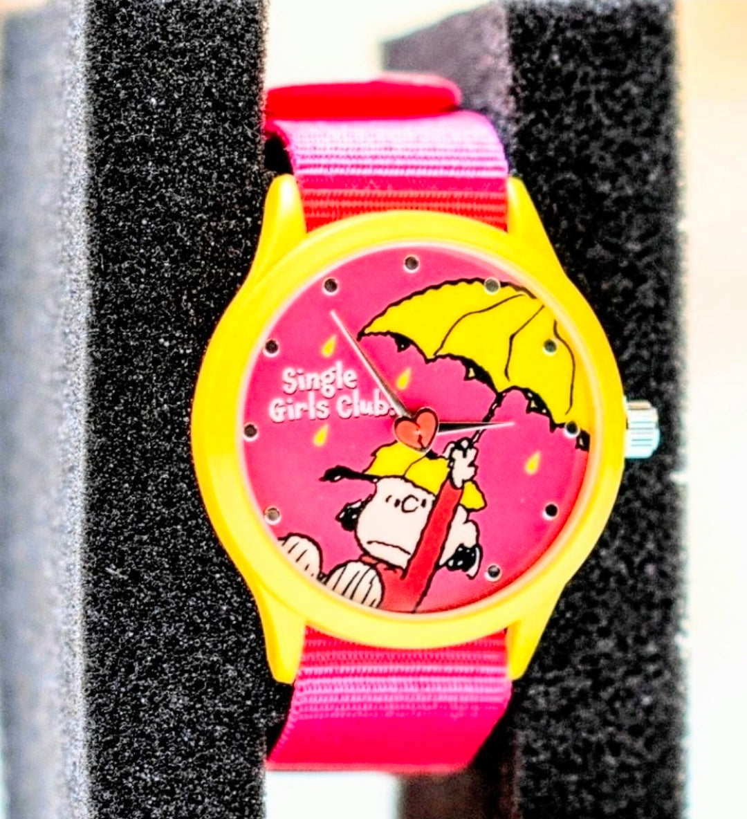 Kids wristwatch with pink fabric strap, yellow bezel, pink face with umbrella Snoopy art