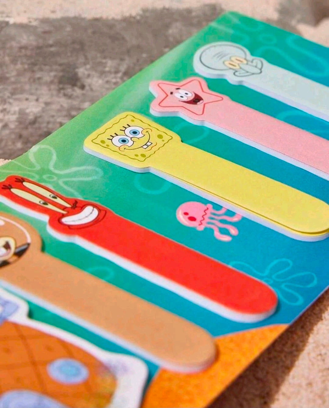 Teal sticky note strips with character cutouts in pink, red, and yellow