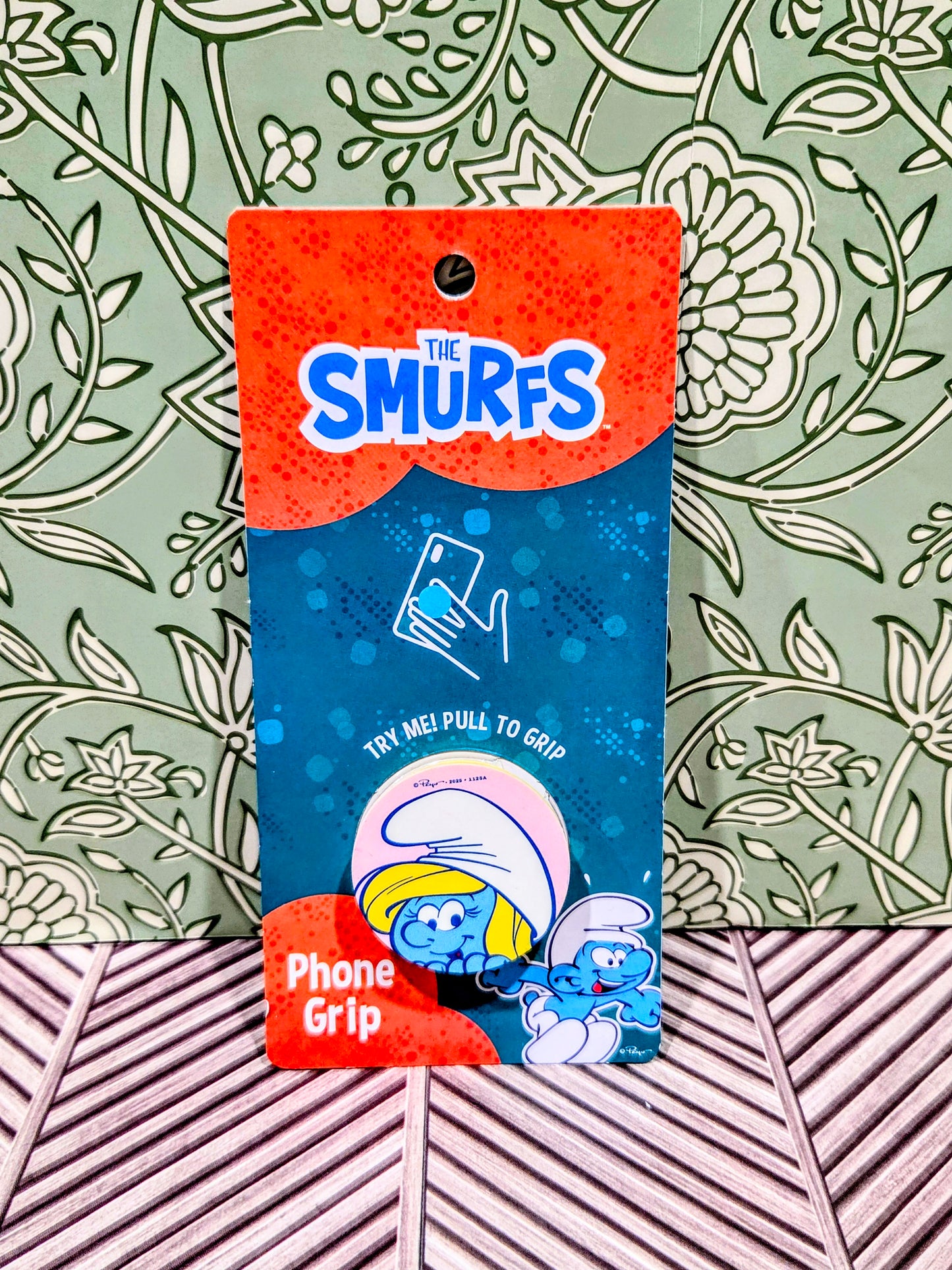 Smurf phone grip holder on blue packaging with The Smurfs logo and try me graphic