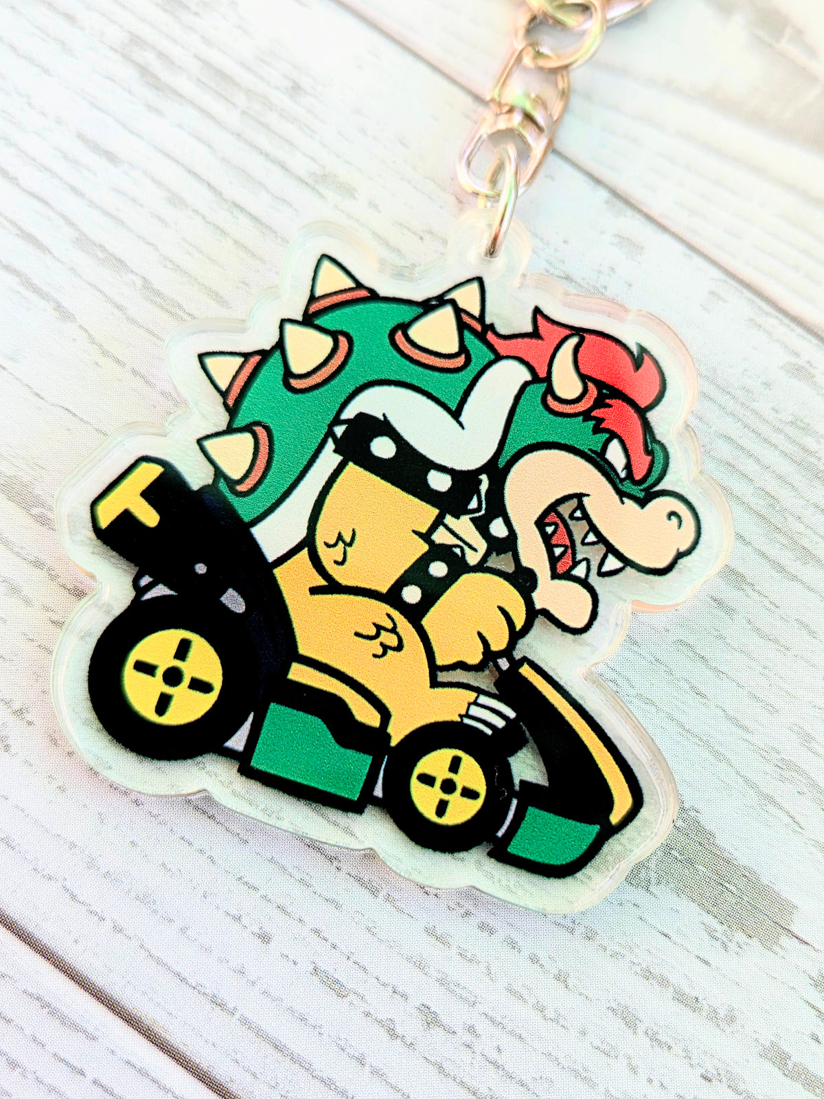 Bowser acrylic keychain charm close-up in a green racing kart