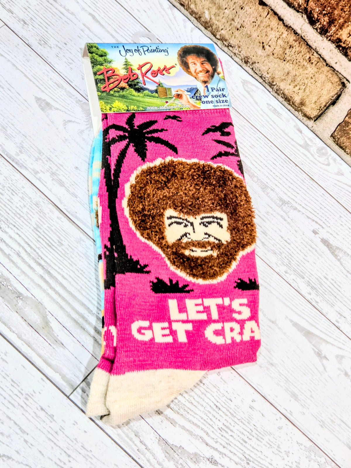Pink crew sock with brown face graphic and 'LET'S GET CRA' lettering