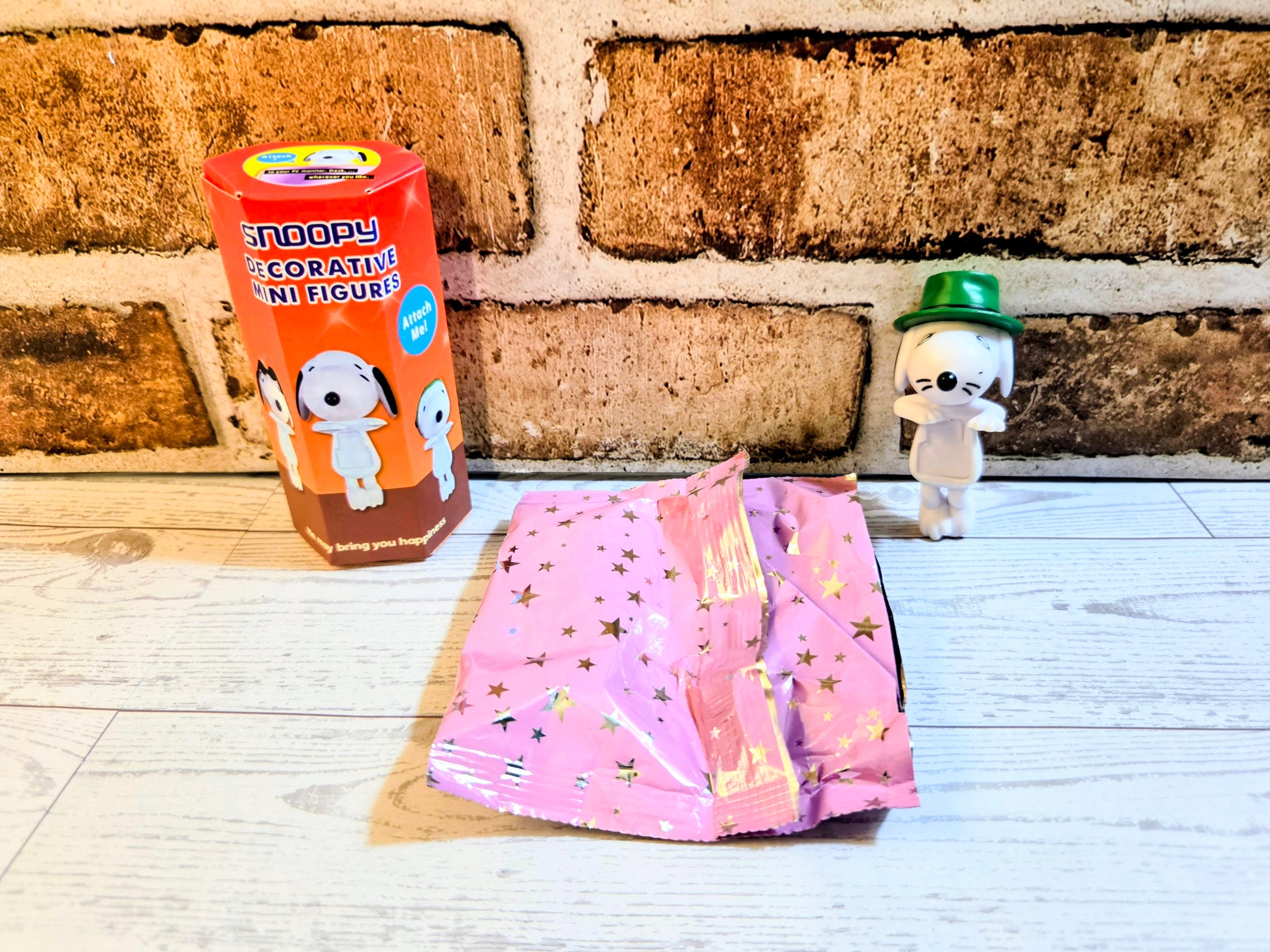 White mini figure with green hat, whiskered face, and pink star skirt