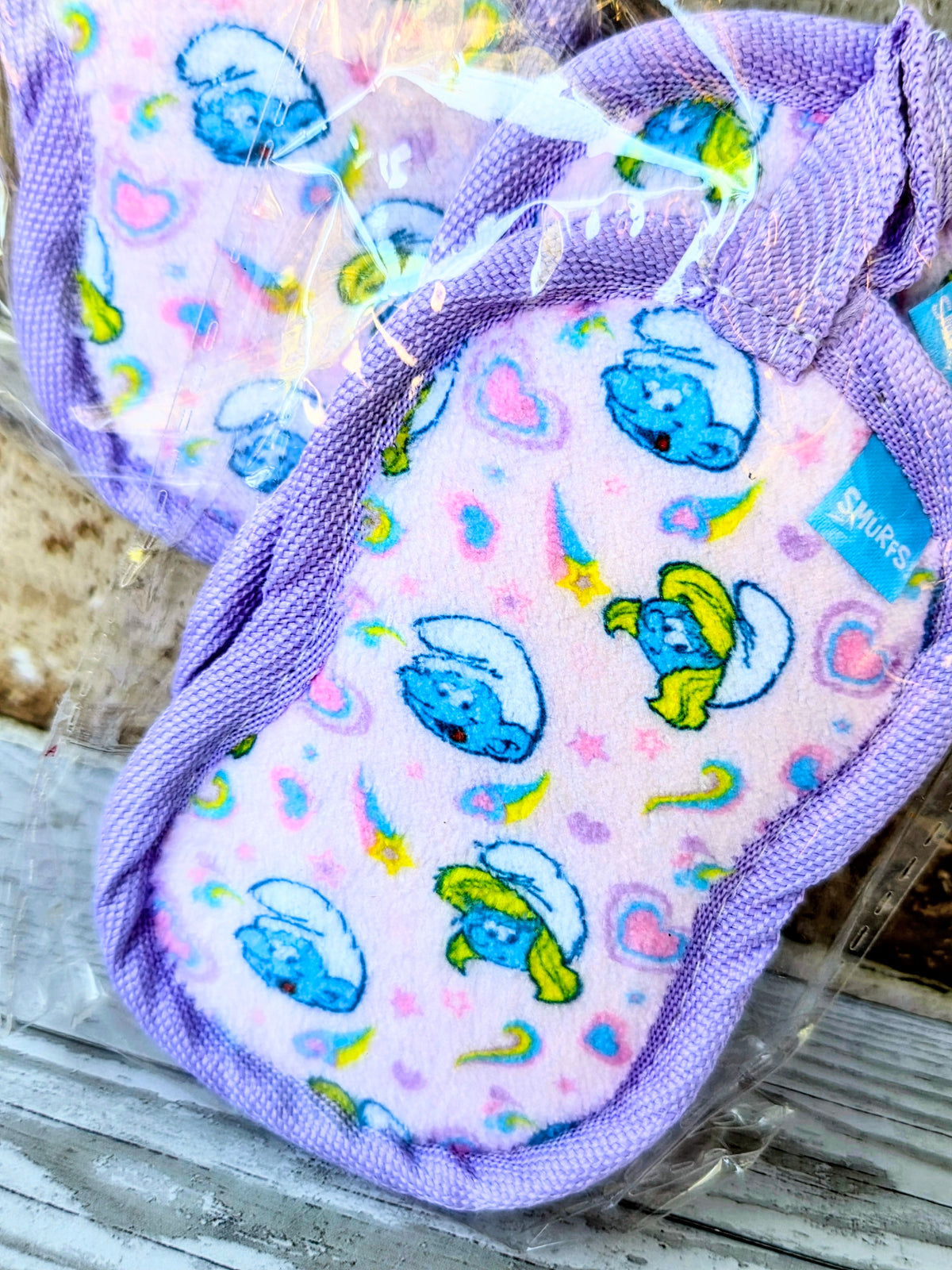 Purple socks with small blue character faces and colorful star and icon pattern