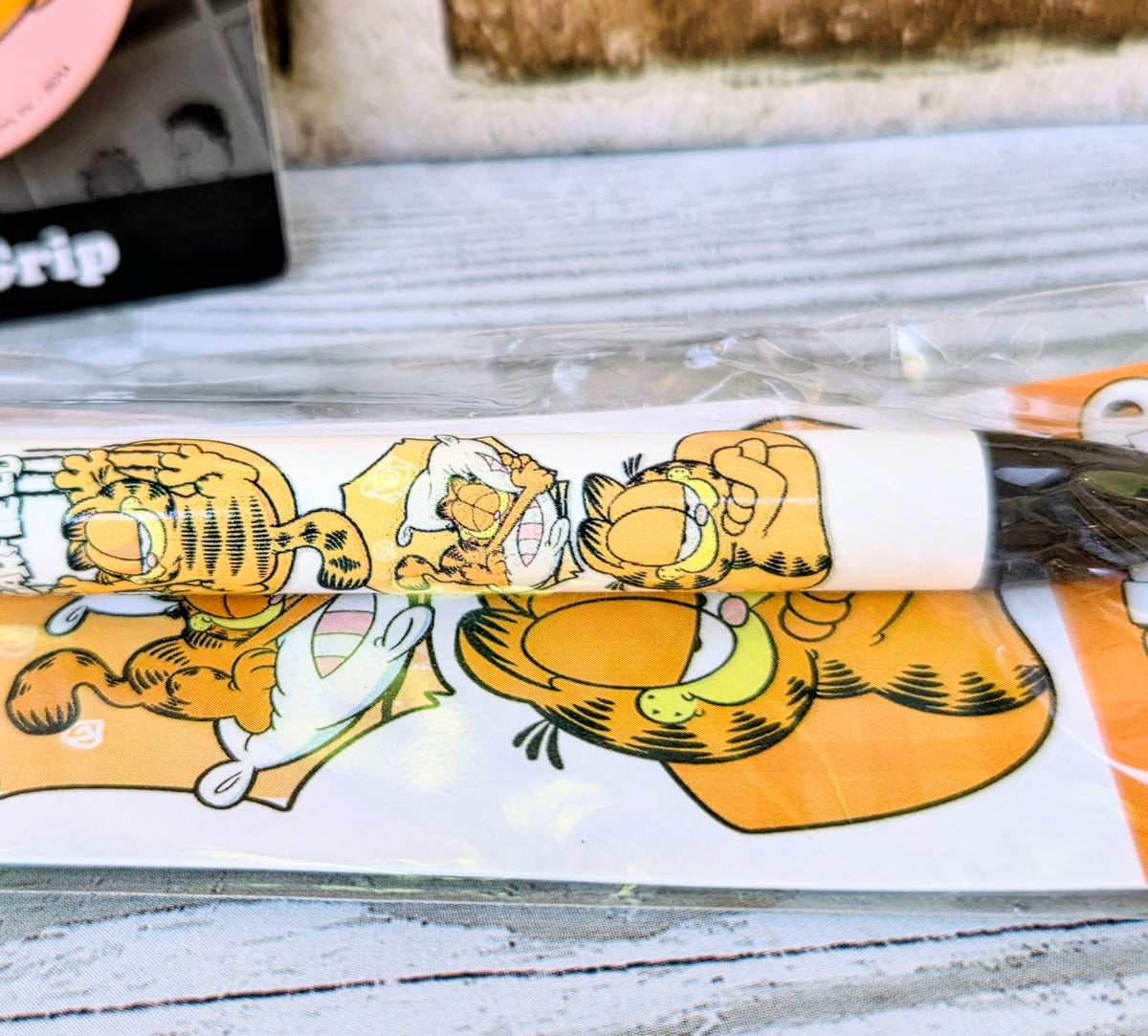 Garfield phone grip strip with cartoon character graphic on a clear backing