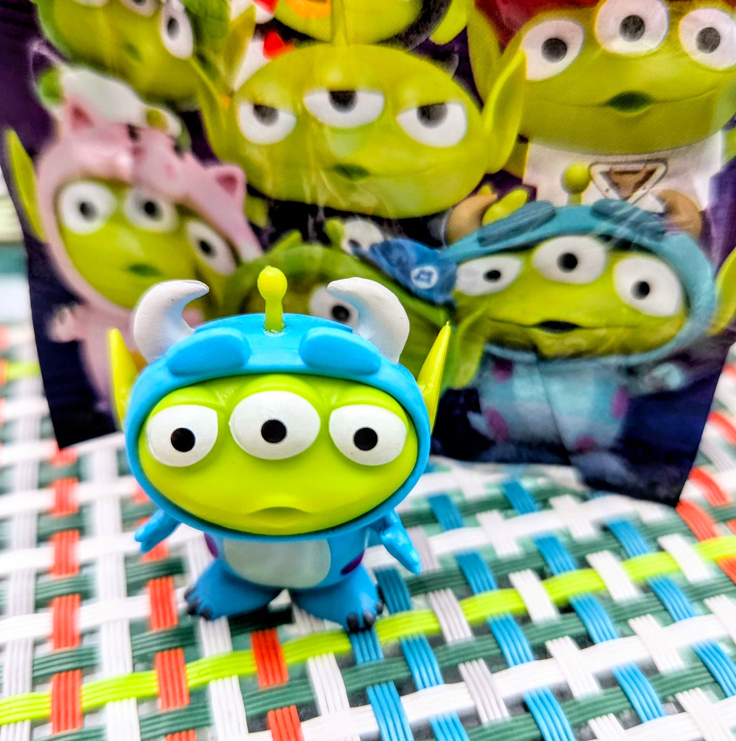 Green alien mini figure wearing a blue helmet with yellow antenna details