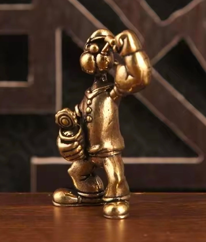 Brass sailor mini statue figure side view with raised right fist and curled tool belt