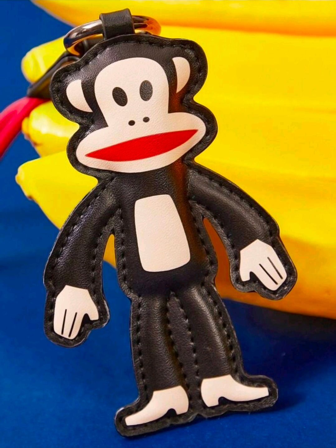 Black Julius monkey bag charm keychain with red-lipped face and stitched details