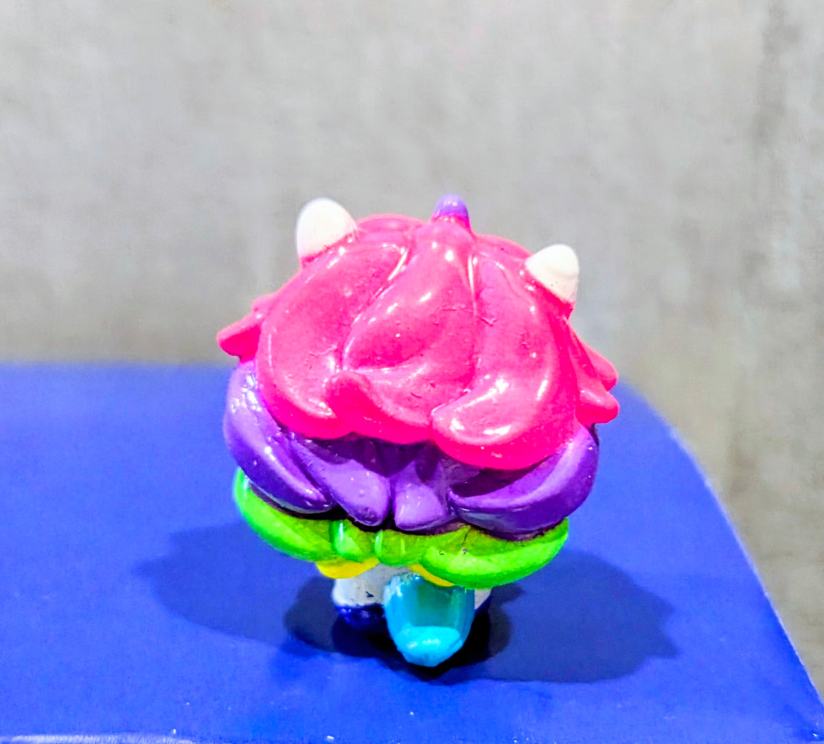 Pink-haired squish head with purple cap, green neck ring and blue base