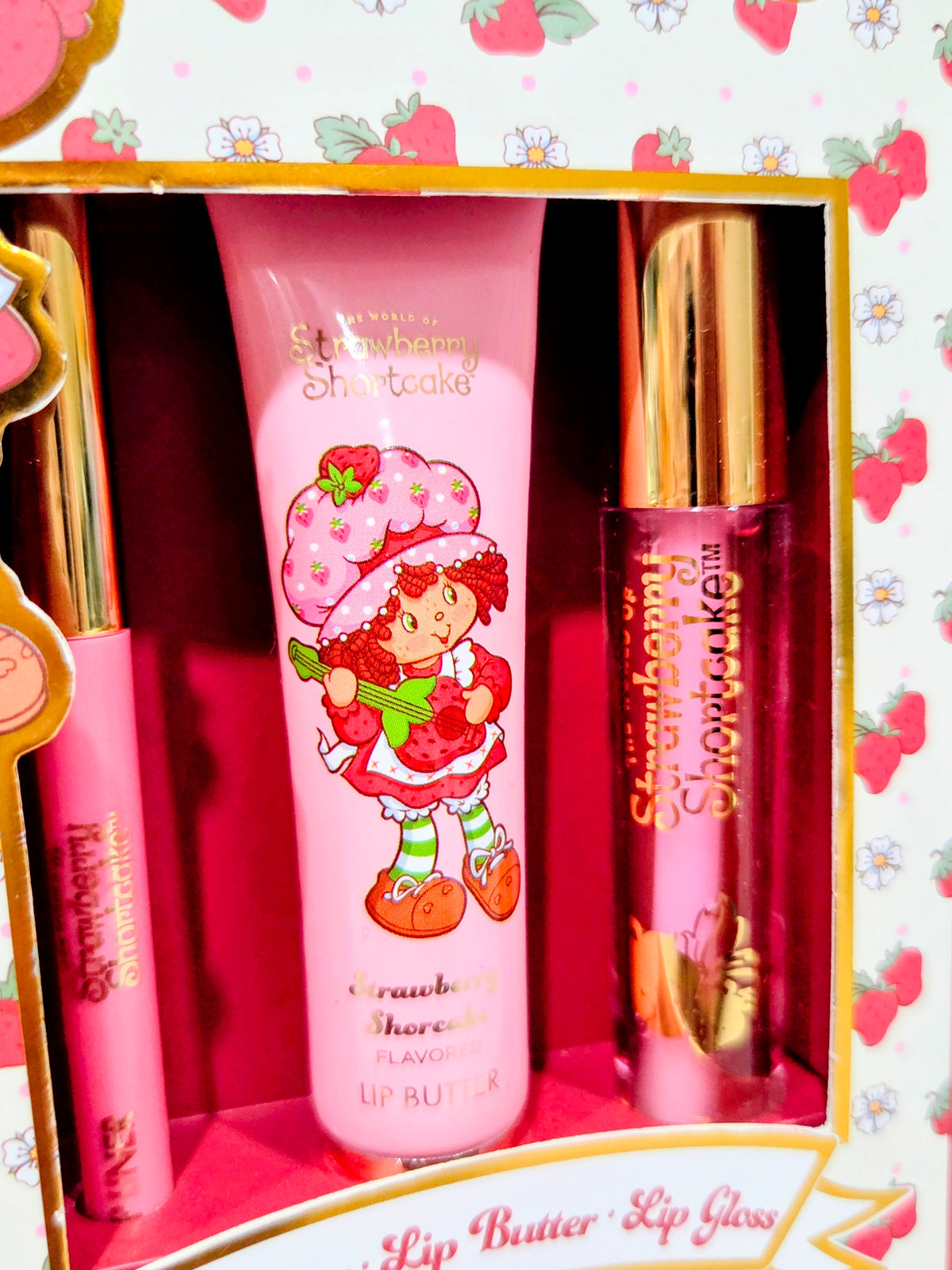 Lip kit set in open box: pink lip butter tube and gold lip gloss bottles