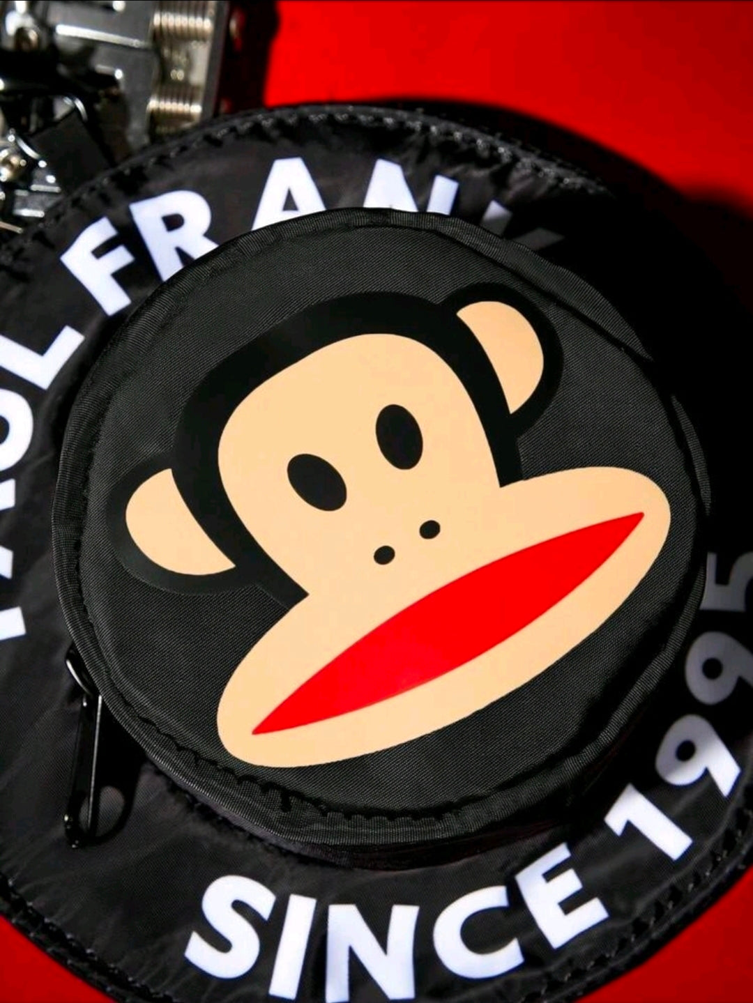 Black round coin pouch with monkey graphic and white lettering around the zipper