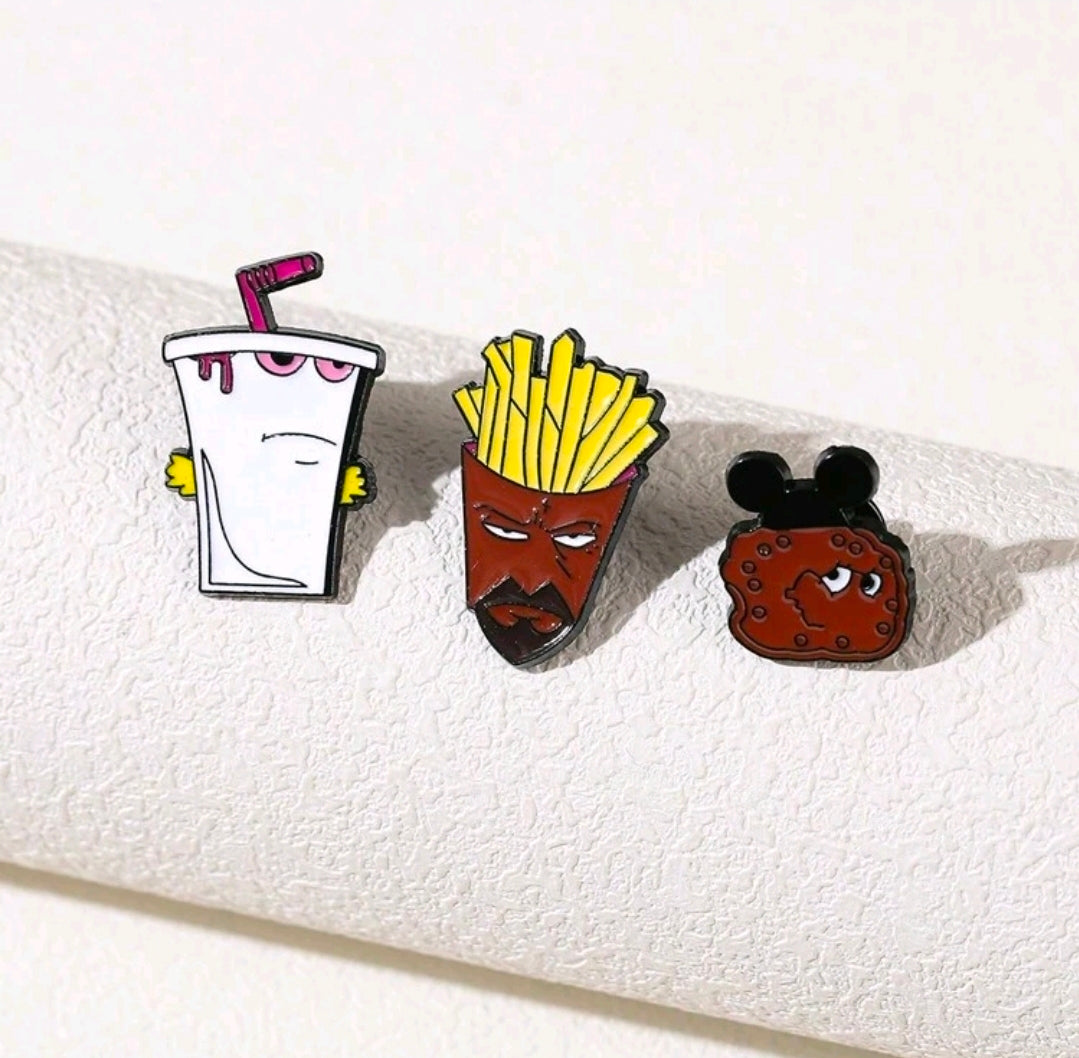 Three enamel character pins: white shake cup, fries face, red cookie with black ears