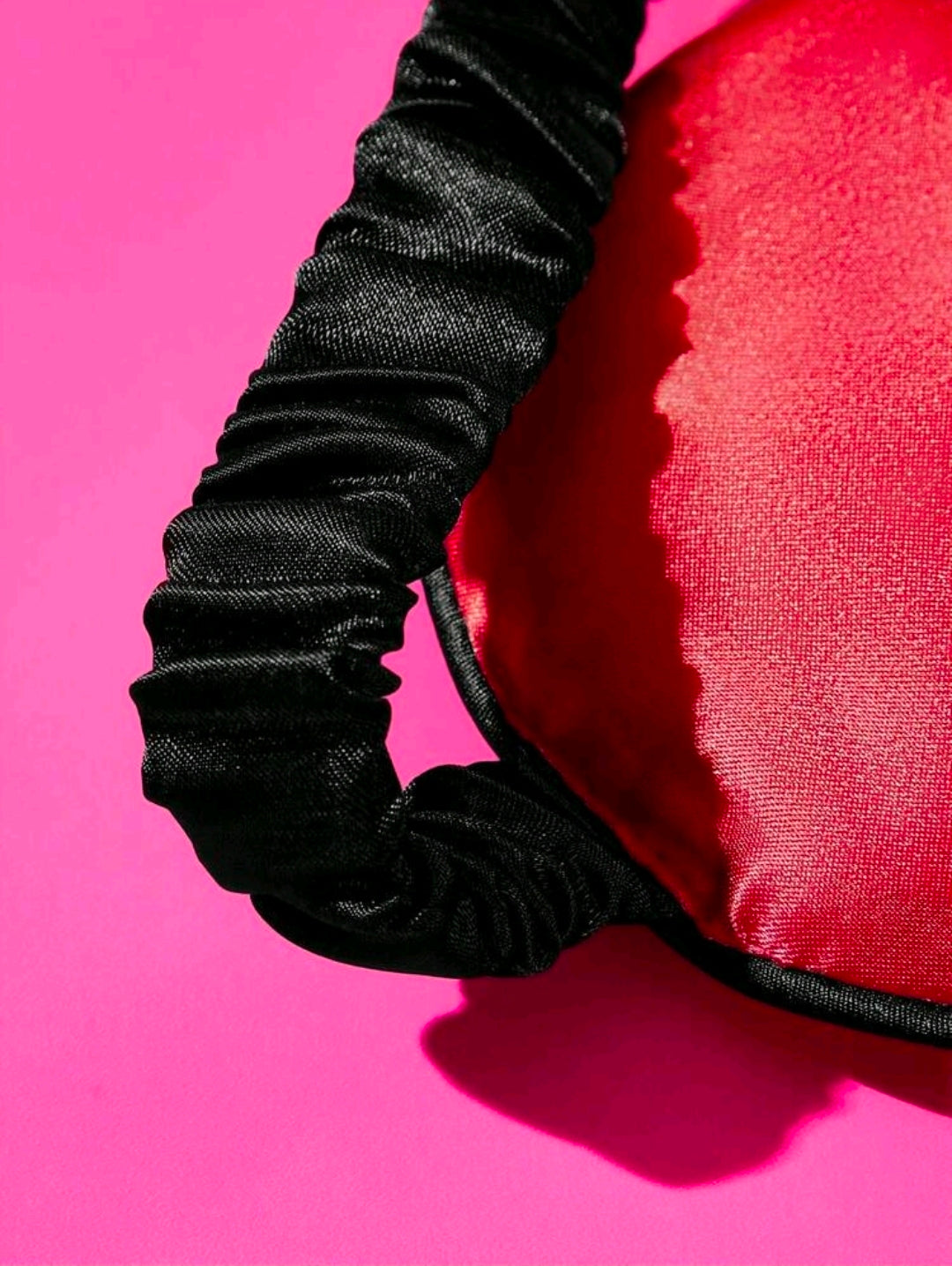 Red satin sleep eye mask with black ruched elastic trim