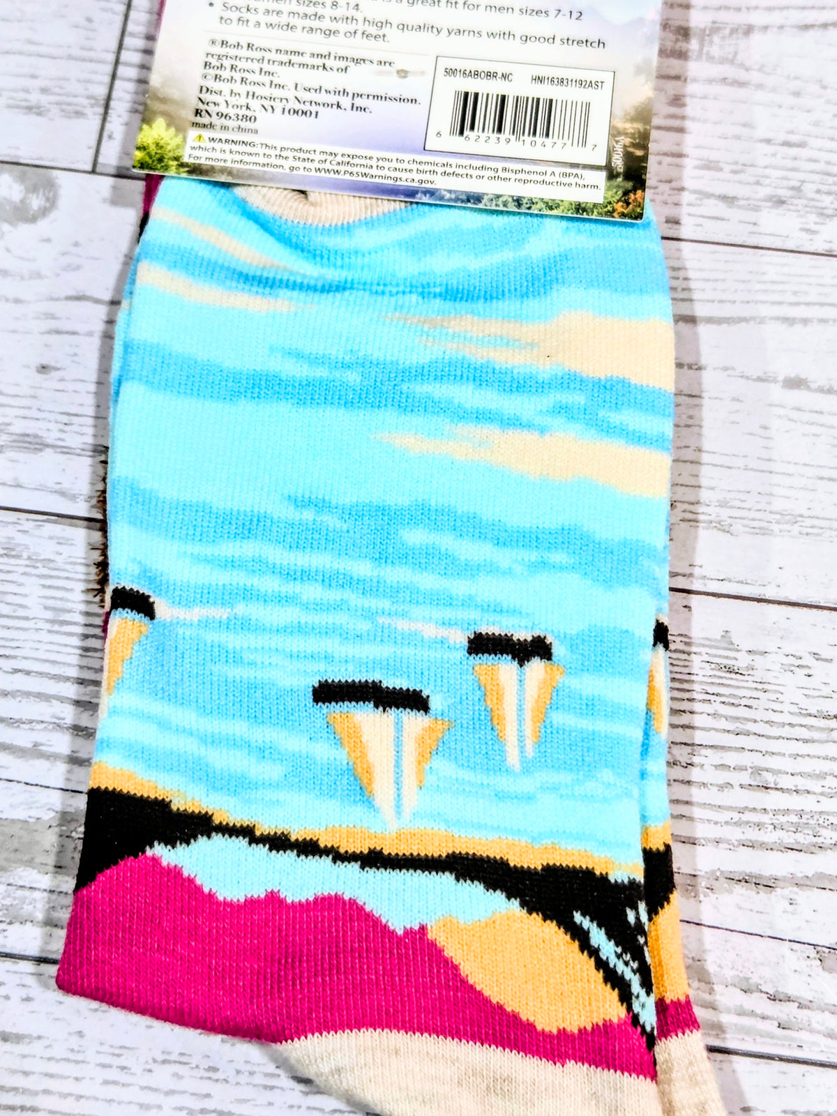 Blue striped crew socks with pink and black graphic at the cuff