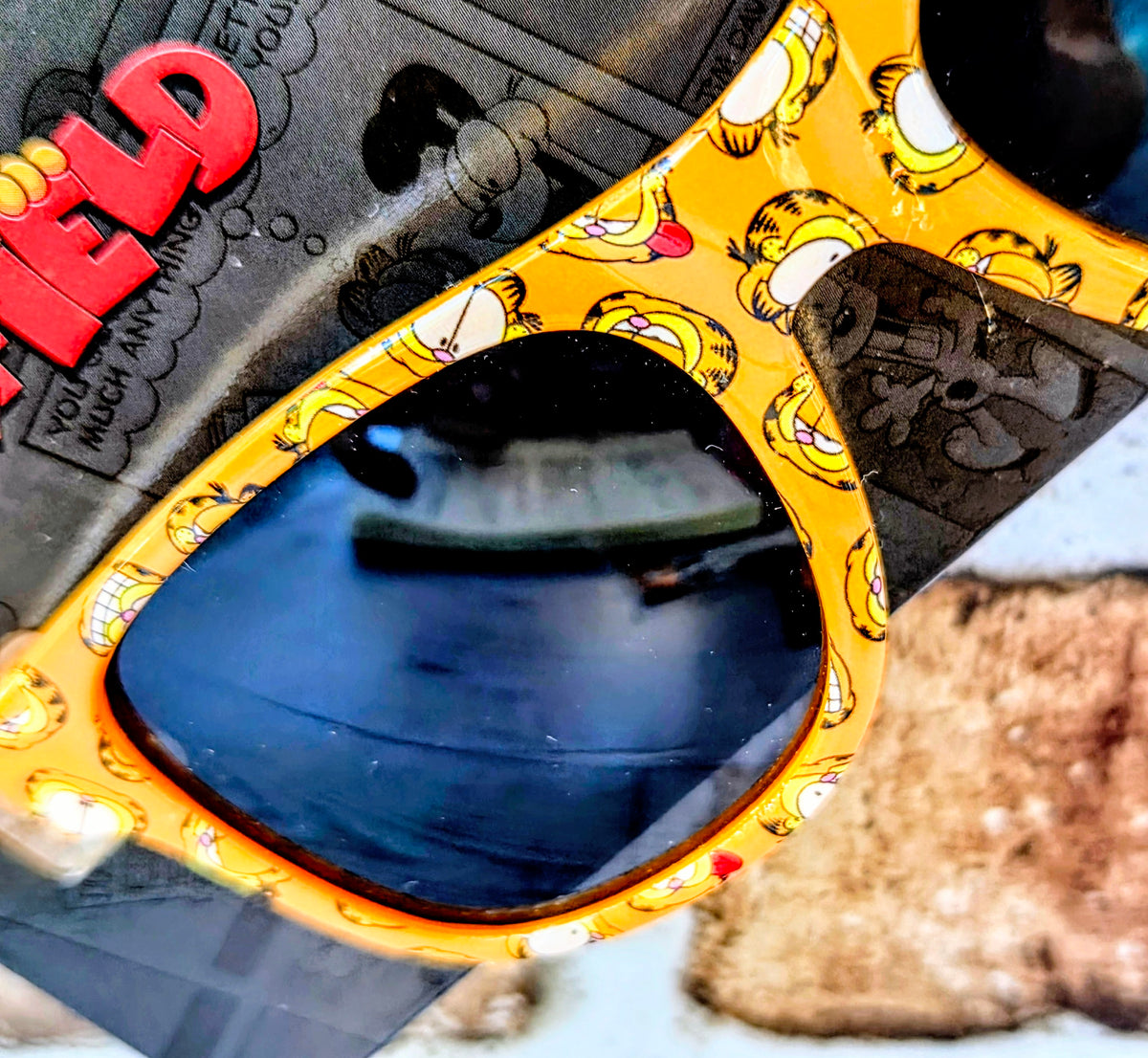 Garfield phone grip shaped like glasses frames with orange print and blue center