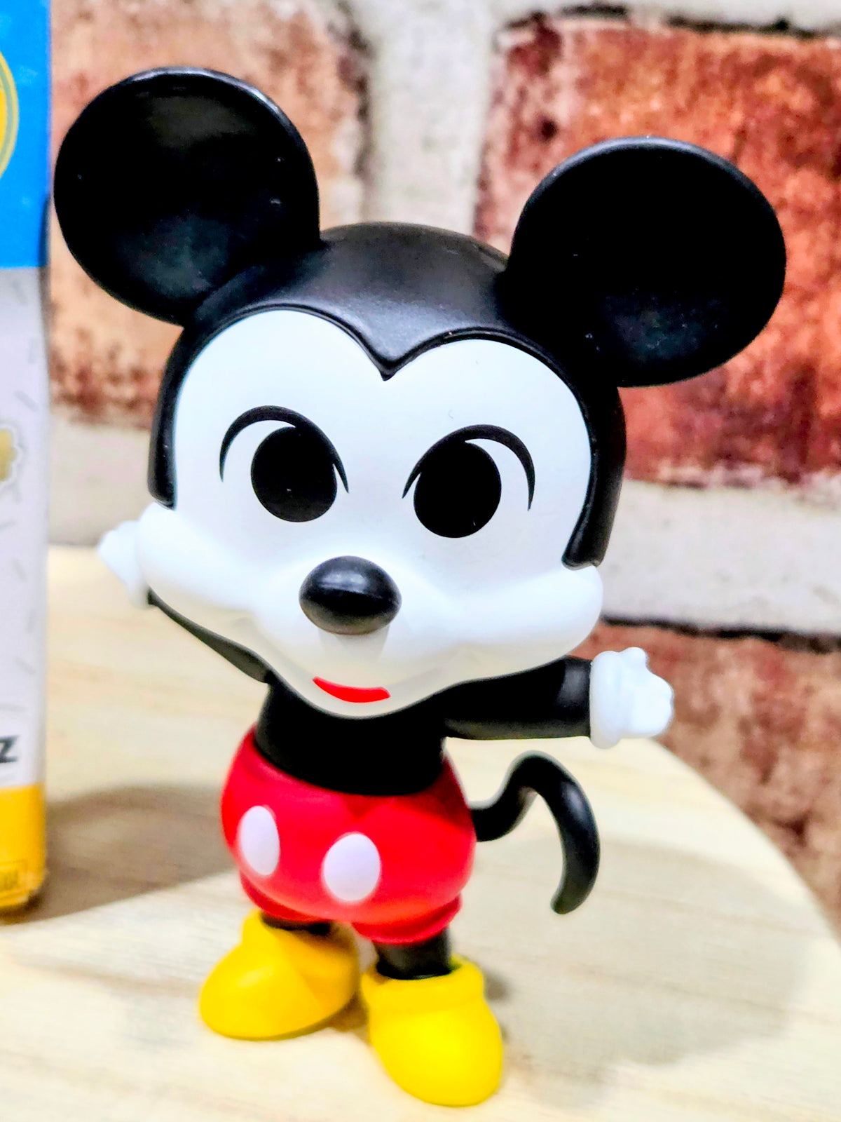 Mickey Mouse vinyl figure, smiling face, red shirt and yellow shoes on base.