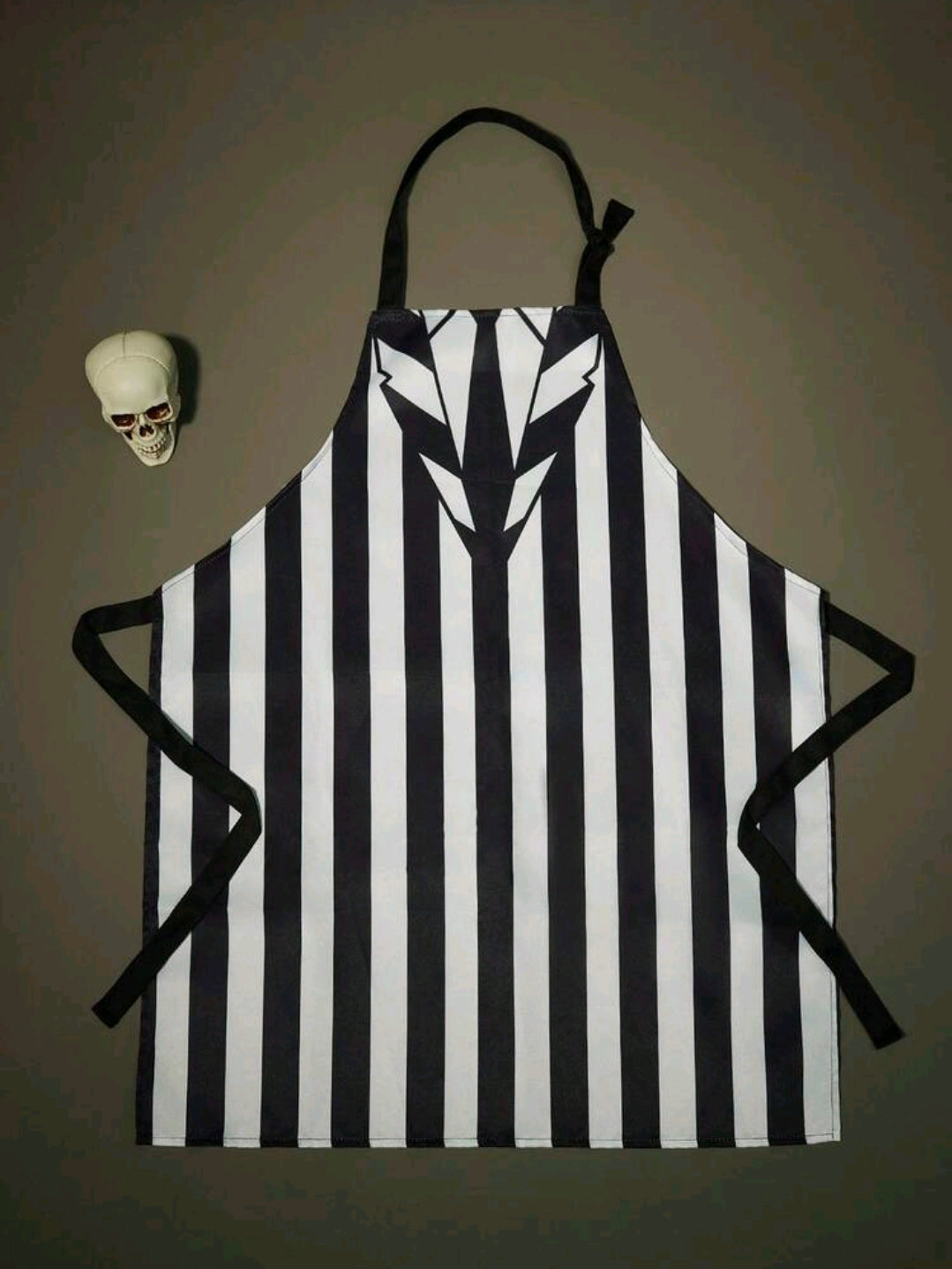 Black-and-white striped cooking apron with tie closure and jagged chest print
