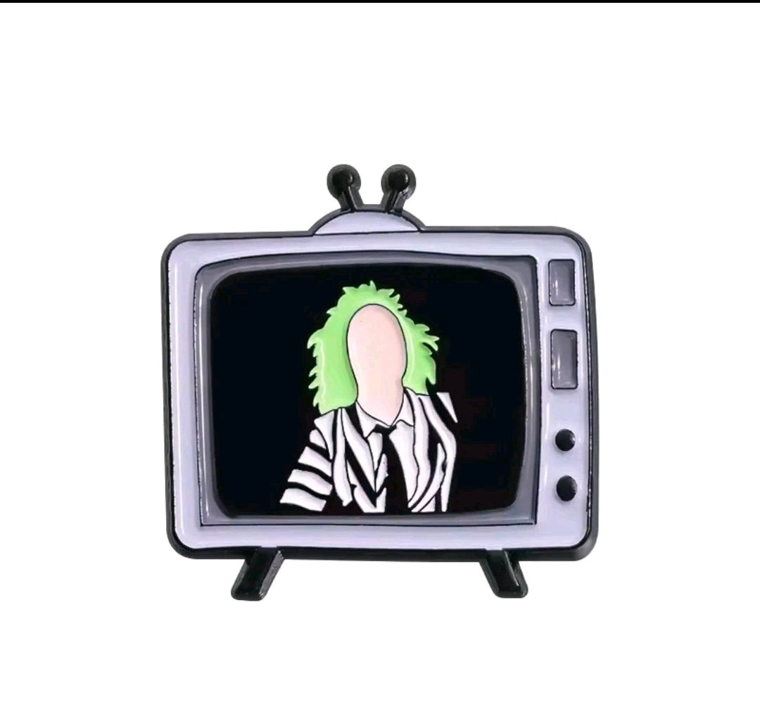 Enamel TV screen pin with a green-haired striped character in a black frame.