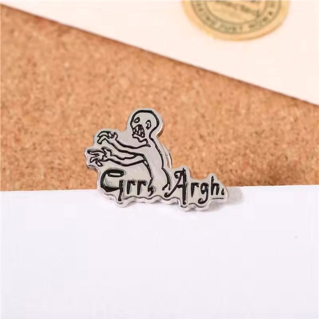 Grr Argh enamel lapel pin on white surface, vampire slayer figure with “Grr Argh”