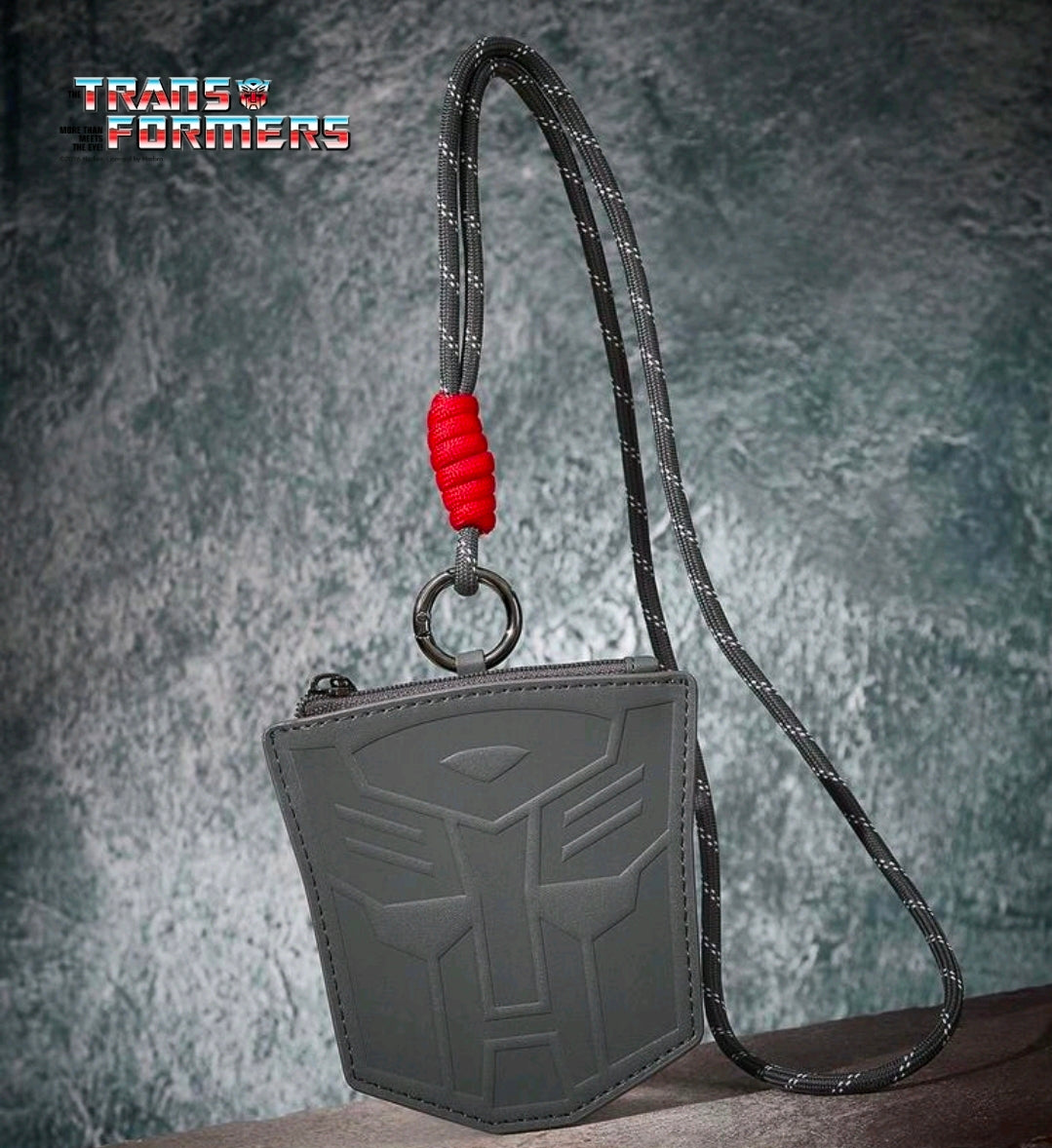 Gray zippered coin purse with embossed Autobot logo, red lanyard cord and metal ring