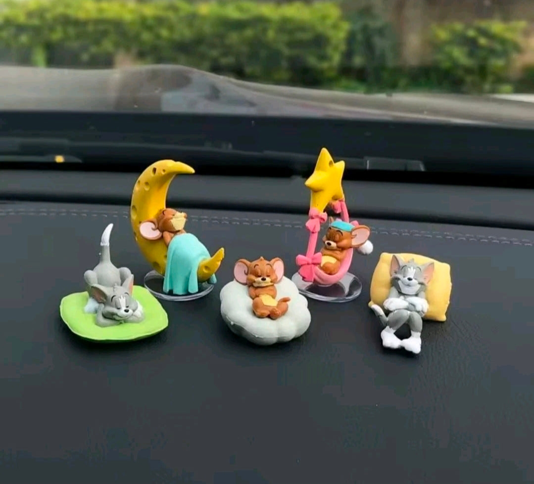 Cat and mouse figurine set with five seated figures on vehicle dashboard
