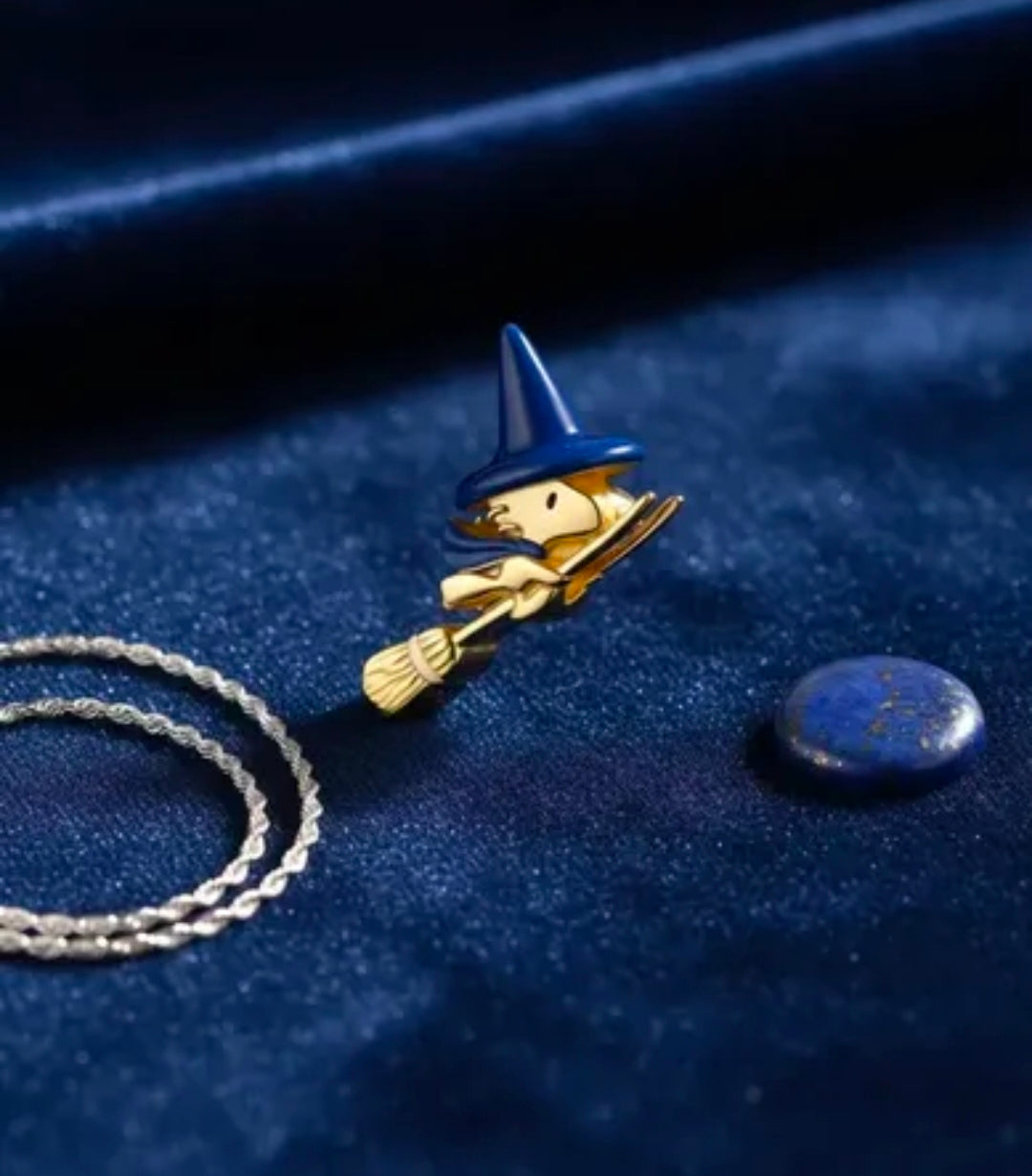 Gold-tone witch charm with blue hat and broom, small detailed pendant